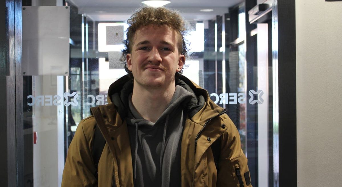 Photo of Jack Mussen in front of a glass window.